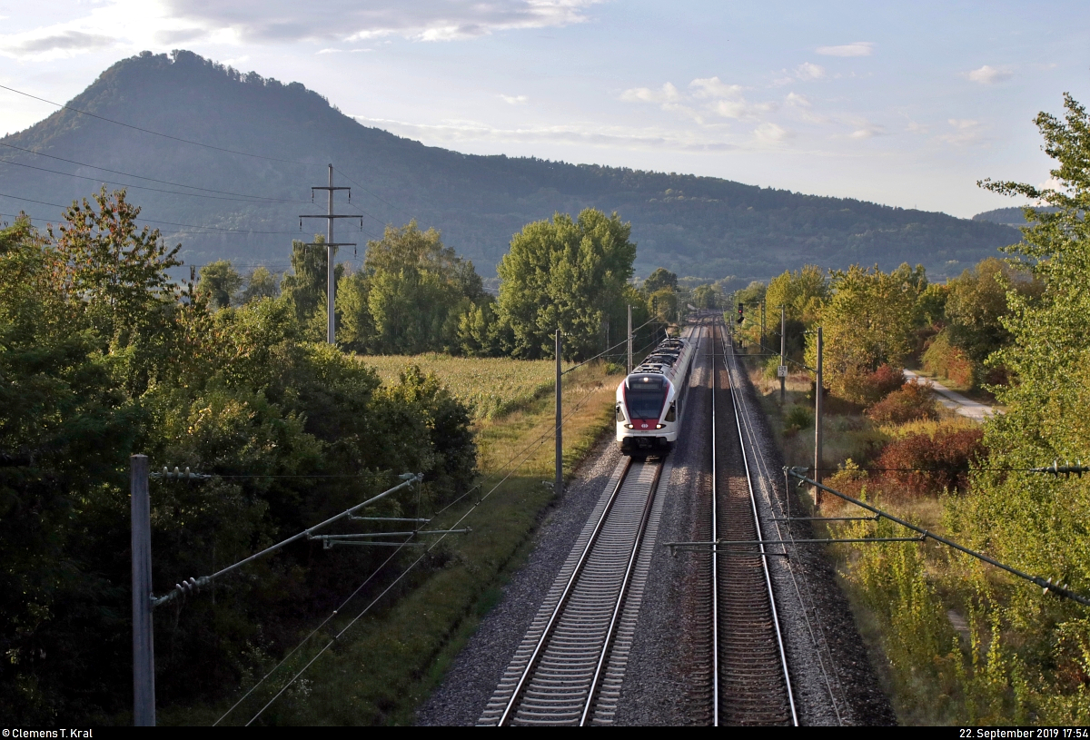 Unter dem Hohenhewen:
RABe 521 201  Konstanz  (Stadler FLIRT) der SBB GmbH (SBB) als SBB87701  Seehas  von Engen nach Konstanz fährt in Engen-Welschingen auf der Bahnstrecke Offenburg–Singen (Schwarzwaldbahn (Baden) | KBS 720).
Aufgenommen im Gegenlicht von einer Brücke.
[22.9.2019 | 17:54 Uhr]