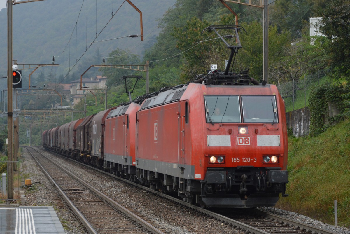 Unter einem Sprühregen, zwei Lokomotiven der Baureihe 185 (185 120-3 die vordere) ziehen einen Güterzug. Mendrisio S. Martino - 30.09.2014