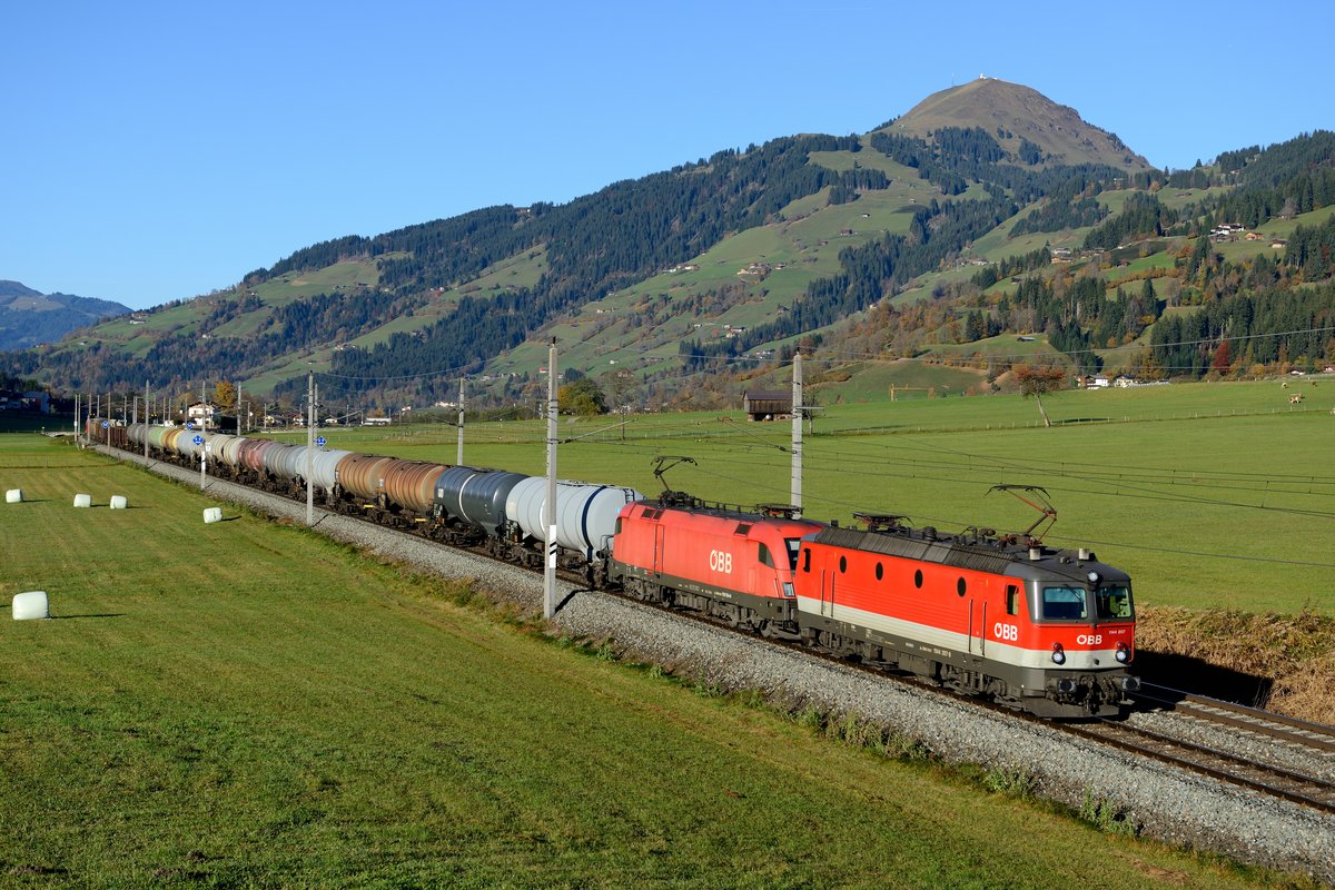 Unter der Kulisse der Hohen Salve bei Brixen im Thale rauscht der 88805 durch das herbstlich eingefärbte Brixental. Dem gemischten Güterzug sind am 26. Oktober 2013 die 1144.207 und die 1116.154 vorgespannt.