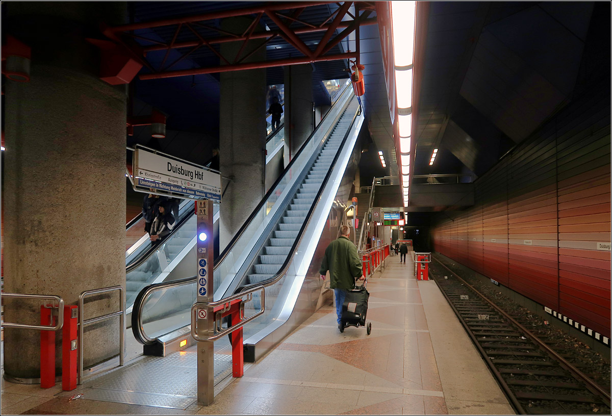 Unterirdisch in Duisburg - 

Am 11.07.1992 wurde die aufwändigen ca. 6 km lange Innenstadttunnelstrecke in Duisburg nach 12 Jahren Bauzeit eröffnet. Es handelt sich eigentlich um zwei Strecken, die zwischen Hauptbahnhof und König-Heinrich-Platz in einem viergleisigen Tunnel gebündelt sind. Eine Strecke führt in der Schwanenstraße über eine Rampe in den Tunnel mit der U-Station Rathaus über König-Heinrich-Platz und Hauptbahnhof zur Rampe in Mülheimer Straße. Die zweite Strecke senkt sich von Süden her in der Heerstraße in den Tunnel ab und verläuft über die Stationen Steinsche Gasse, König-Heinrich-Platz und Hauptbahnhof zur Station Duissern, von wo aus die Straßenbahnen bis zum Jahr 2000 über eine provisorische Rampe wieder an die Oberfläche kamen. Da in der zweiten Strecke auch die hochflurige Stadtbahnlinie U79 aus Düsseldorf verkehrt, wurden die Bahnsteige zu zwei Drittel als Hochbahnsteige ausgeführt.
Das Bild zeigt die obere Ebene der doppelstöckigen viergleisigen Station Hauptbahnhof. Hier fahren die Züge in Richtung Mülheim, Meiderich und Dinslaken ab.

15.10.2019 (M)