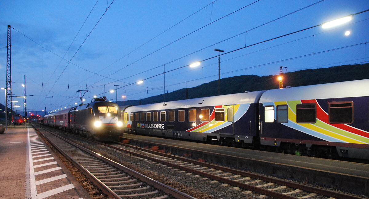URLAUBS-EXPRESS UEx 1384 mit ES64 U2 026 von Verona nach Düsseldorf, dahinter UEx 1394 nach Hamburg-Atona in Gemünden/Main beim Betriebshalt (planmäßig an 3:07, ab 4:08 Uhr). Mit gut einstündiger Verspätung im Morgengrauen des 27.06.2021.