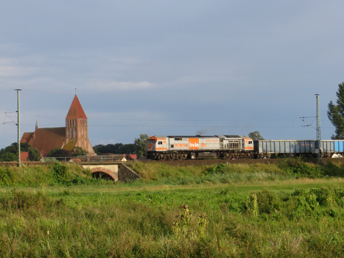 V 330.4 der HVLE am 15.08.2014 bei der Ausfahrt in Grimmen in Richtung Stralsund mit beeindruckender Stadtkulisse im Hintergrund. Der Zug ging nach Staßfurt und brachte Splitt zum örtlichen Baustoffhändler. 