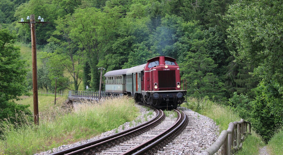 V100 2084 der Schwäbischen Waldbahn zieht ihre 2 Wagen bei Rudersberg Klaffenbach die Steigung nach Welzheim hinauf.