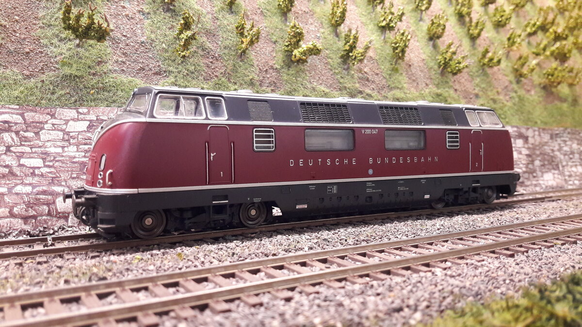 V200, ab 1953 die erste große Neuentwicklung der DB nach dem Kriege in Sachen Dieselloks.
5 Vorserienloks, zu erkennen an den fehlenden Lüftereinlässen über den Frontlampen.
Serienmaschen ab 1956, mit den großen Seitenfenstern. Ab Nummer 056 änderte sich der Schriftzug von   Deutsche Bundesbahn in den DB Keks. Ab 1962 , kam die V200.1 ( heutige 221, zu erkennen an den geänderten Seitenfront, eine flachere Front und einem anderen Dachaufbau (musste aus Grund der neuen Motoren sein).  Hier nun das Modell der ersten Serienloks mit Schriftzug Deutsche Bundesbahn,  V200 047  Modell Piko 59700 DC digital
