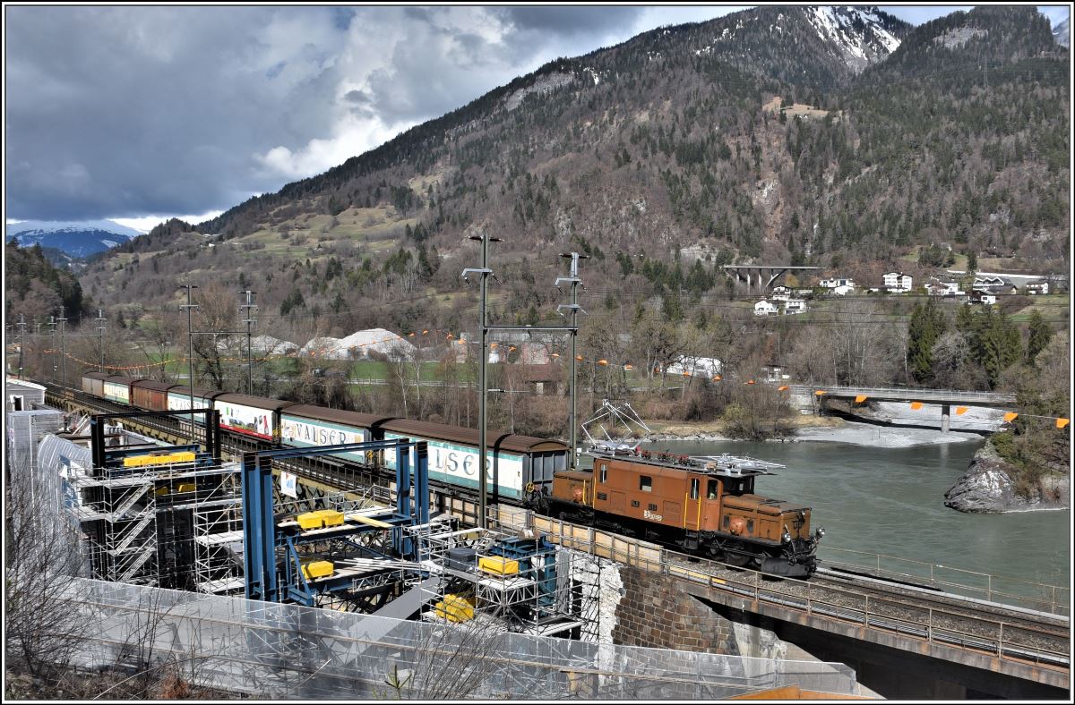 Valserwasserzug mit Ge 6/6 I 414 bei der Baustelle zur zweiten Hinterrheinbrücke in Reichenau-Tamins. (05.04.2018)