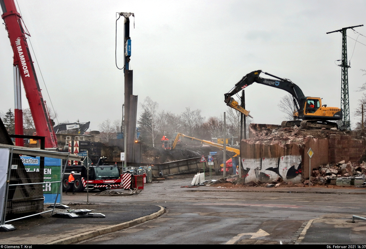 VDE 8 Komplexmaßnahme Halle Rosengarten–Angersdorf
▶ Standort: Halle Rosengarten

Mehr Baustelle geht nicht.
Am vergangenen Wochenende wurde das Areal am Hp Halle Rosengarten durch den Abriss zweier Stahlbrücken auf den Kopf gestellt. Nach dem Ausheben der Brücken mithilfe großer mobiler Kräne (links im Bild angedeutet) werden die einzelnen Teile für die Verschrottung zerkleinert (Mitte, Hintergrund) und die Widerlager abgetragen (rechts). Zudem ist eine Ramme mit dem Setzen von Spundwandelementen beschäftigt.
Aufgenommen hinter den Absperrungen auf der Kasseler Straße.

🕓 6.2.2021 | 16:37 Uhr