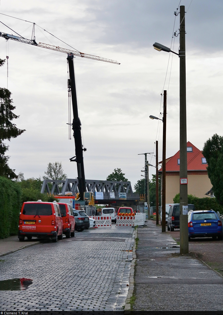 VDE 8 Komplexmaßnahme Halle Rosengarten–Angersdorf
▶ Standort: Halle Rosengarten

Gleich drei Brücken wurden am 9. und 10. Juli in der Merseburger Straße in Halle (Saale) eingeschoben. Dafür kam auch ein Schwerlastkran zum Einsatz. Ebenso waren Mitarbeiter einer niederländischen Spezialfirma vor Ort - erkennbar an den gelben Kennzeichen der Fahrzeuge.
Im Hintergrund wurde bereits die Argentinierbrücke in ihre Position gebracht, wie hier hinter der weiträumigen Absperrung in der Kasseler Straße festgehalten. Der Einbau der zweiteiligen Rosengartenbrücke verzögerte sich am nächsten Tag um mehrere Stunden wegen Schwierigkeiten bei der Anlieferung. Dennoch ging später alles rechtzeitig über die Bühne.

🚩 Bahnstrecke Halle–Hann. Münden (KBS 590)
🕓 9.7.2021 | 20:42 Uhr