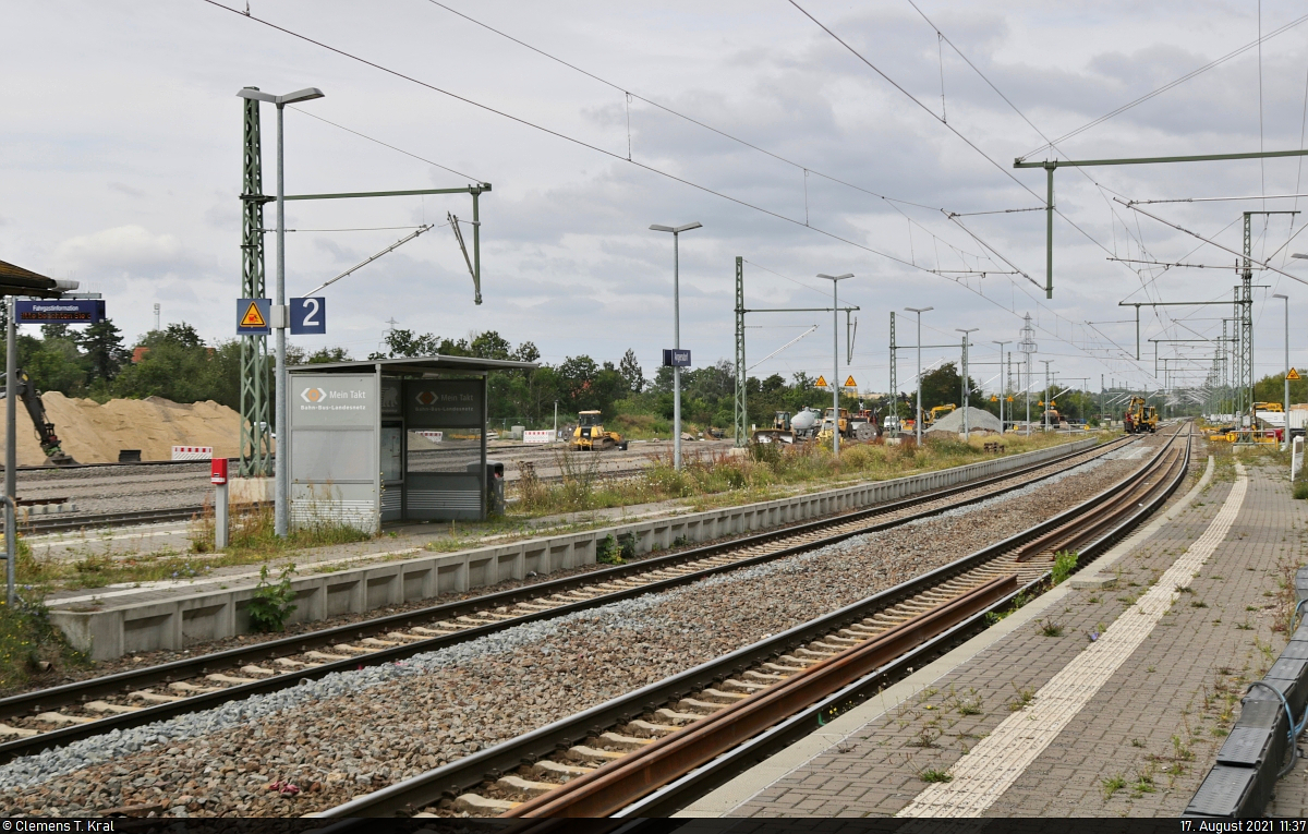 VDE 8 Komplexmaßnahme Halle Rosengarten–Angersdorf
▶ Standort: Bahnhof Angersdorf

Während der ungenutzte Bahnsteig 2/3 vor sich hin wuchert, haben die Bauleute in der künftigen Abstellanlage im Hintergrund noch tüchtig zu tun. Es scheint so, als würden nur die Gleise 1 bis 4 wieder elektrifiziert werden. Zumindest stehen zum Aufnahmezeitpunkt nur dort erst einmal die neuen Masten.
Spätestens ab dem 29.11.2021, wenn der Verkehr nach knapp 11 Monaten wieder anrollen soll, wird sich das Ergebnis zeigen.

🚩 Bahnstrecke Halle–Hann. Münden (KBS 590)
🕓 17.8.2021 | 11:37 Uhr