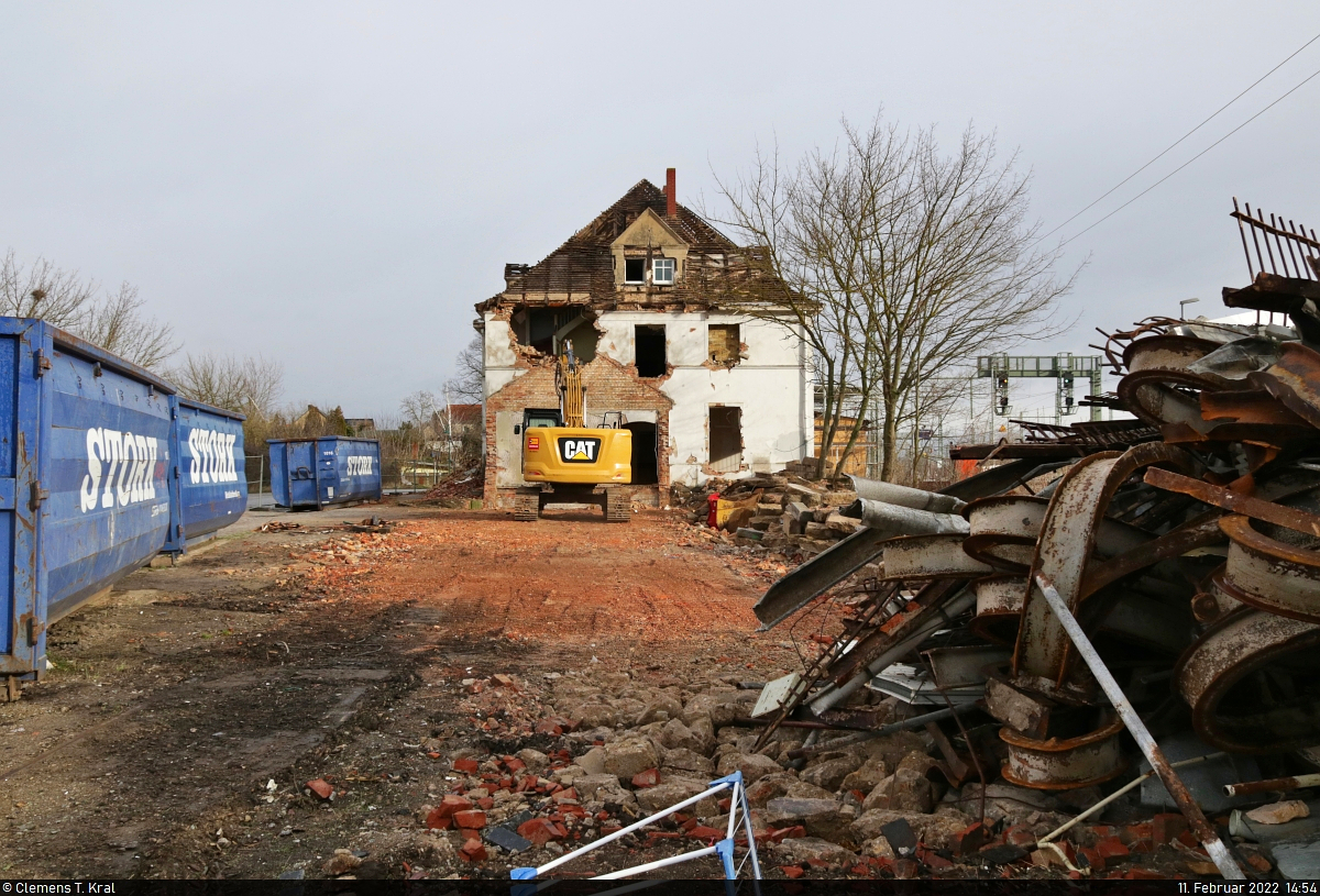 VDE 8 Komplexmaßnahme Halle Rosengarten–Angersdorf
▶ Standort: Bahnhof Angersdorf

Der Abriss des Empfangsgebäudes. Nachdem bereits die beiden Stellwerke und der Güterschuppen abgerissen wurden, geht es nun auch dem dreistöckigen Empfangsgebäude an den Kragen. Einige Fenster und Türen sind bereits draußen und der Schrott stapelt sich auf dem Baufeld.
Die Aufnahme erfolgte durch den Bauzaun.

🕓 11.2.2022 | 14:54 Uhr