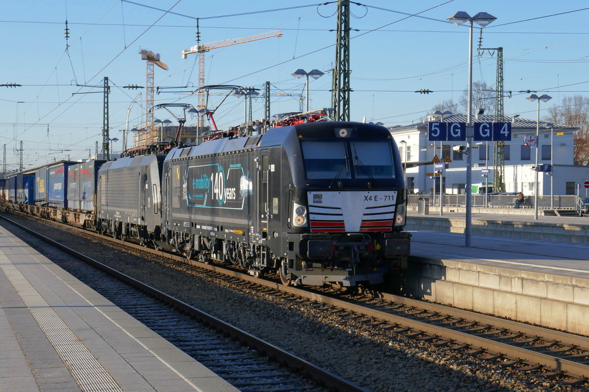 Vectron 193 711 und Lok 189 924, beide von MRCE, durchfahren mit einem Zug des kombinierten Ladungsverkehrs den Bahnhof Rosenheim, an der stark befahrenen Hauptstrecke München - Kufstein, mit Abzweig nach Salzburg.
Der führende Vectron wirbt für Siemens mobility - Elektromobilität begann bereits vor 140 Jahren!
Rosenheim, 4. Dezember 2019.