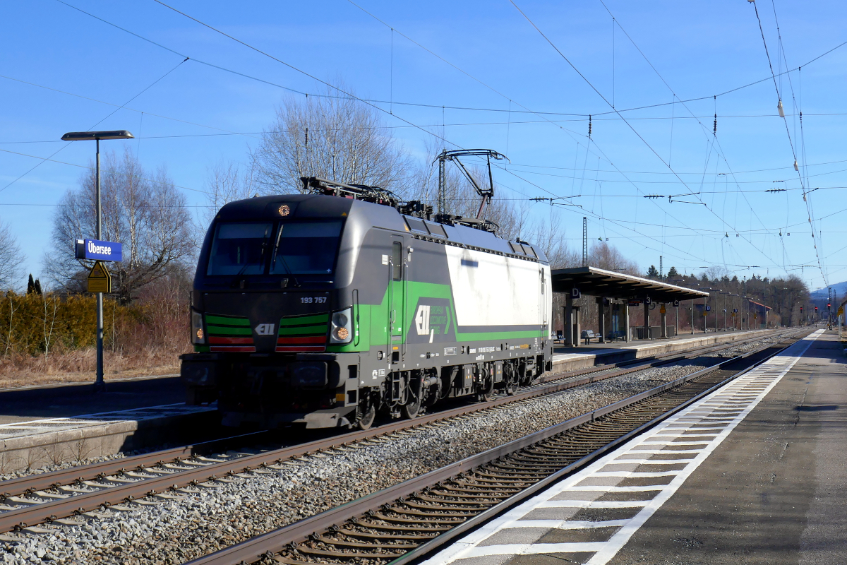 Vectron 193 757 des Vermieters ELL durchfährt leer den Bahnhof Übersee, etwa auf dem halben Weg zwischen Salzburg und Rosenheim. Schaut man genau hin, so scheint irgend etwas mit dem Farbschema nicht zu stimmen. Übersee am Chiemsee, 10. Februar 2022
