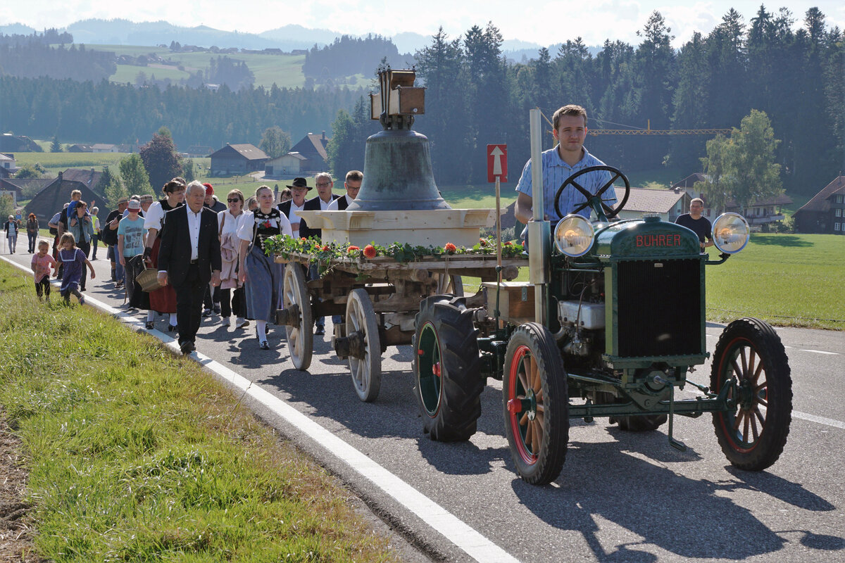 Verein Historische Eisenbahn Emmental (VHE).
Verein Dampfbahn Bern (VDBB).
Eine revidierte Glocke der reformierten Kirche Affoltern im Emmental auf dem Rückweg am 11. September 2021.
Schon zu Grossvaters Zeiten funktionierte der kombinierte Güter- und Personenverkehr auf Strasse und Schiene.
Ein SAURER Lastwagen mit Kran brachte die revidierte Glocke in die Nähe der ehemaligen VHB Station Ei.
Mit dem „GLOCKENZUG“ des VDBB bestehend aus der E 3/3 853, dem neuen Aussichtswagen GME sowie dem Flachwagen S4t ging die gemütliche Fahrt weiter via Sumiswald Grünen nach Affoltern-Weier Bahnhof, ehemals VHB.
Anschliessend historische Umladung der Glocke auf dem Bahnhof Affoltern-Weier.
Ein historischer Traktor der Marke BÜHRER brachte die Glocke auf passendem Beiwagen zur reformierten Kirche Affoltern im Emmental. 
Die eher sportlichen Festbesuchern begleiteten die Glocke zusammen mit dem Traktor zu Fuss.
Für die älteren Festbesucher stand ein historisches Postauto der Marke SAURER im Einsatz.
Zum Traktor: Ausnahmsweise unter Bahnen eingestellt da Bestandteil einer historischen Serie. 
Foto: Walter Ruetsch
