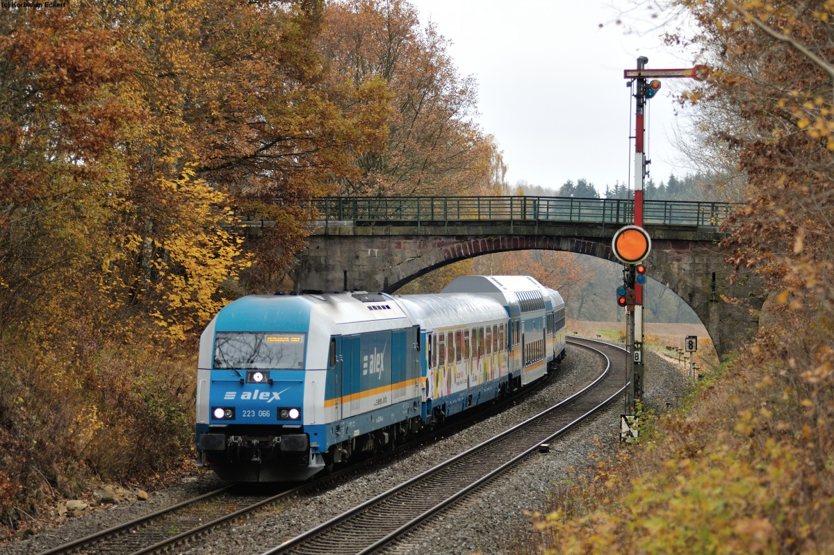 Vereinzelt gibt es sie noch die Formsignale, wie hier bei Reuth. Die typischen Brücken an der KBS 855 (Regensburg-Hof) sind auch keine Selbstverständlichkeit. Eine mögliche Elektrifizierung würde dabei nicht nur das Ende der Brücken bedeuten, sondern wohl auch das Ende der Formsignale an dieser Strecke. 
Am 11.09.2014 gaben sowohl Brücke als auch Formsignal umrahmt mit herbstlicher Stimmung ein gutes Bild ab, als 223 066 mit ALX 84115 (Hof-München Hbf) vorbeikam.