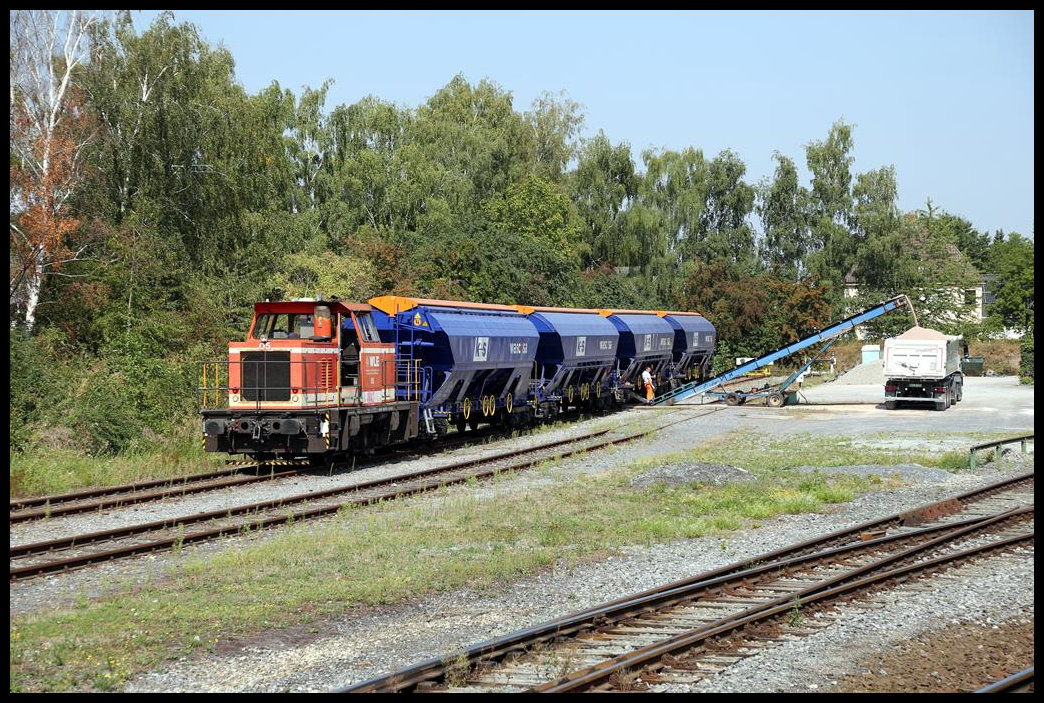 Verladeszene im Bahnhof Erwitte am 23.08.2019: WLE 05 Lok schiebt die mit Düngemitteln beladenen Wagen passend zu einer Entladestelle, wo per Förderband die LKW beladen werden.