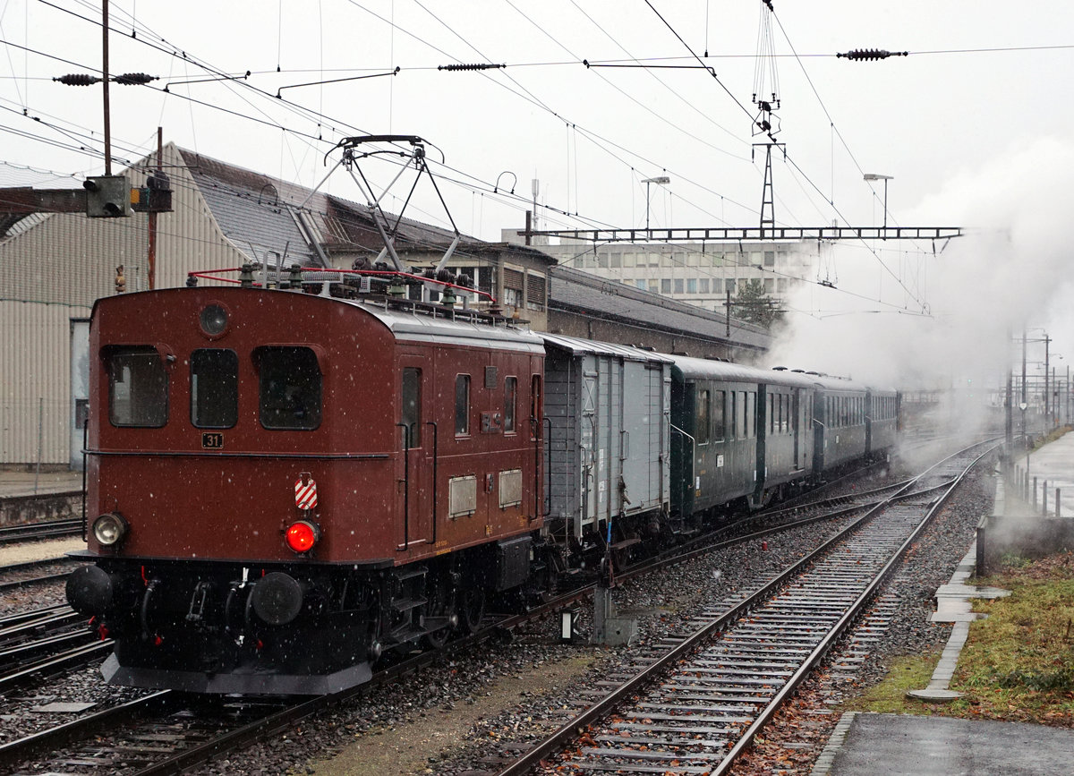 VHE/Verein Historische Eisenbahn Emmental:
Impressionen der tra­di­ti­o­nellen Fonduefahrt vom 20. Januar 2018 die leider bei sehr schlechtem Wetter stattfand. Die voll ausgebuchte Fahrt führte von Huttwil ab 13.05h via Langenthal - Burgdorf - Solothurn - Oensingen  bis Balsthal, wo der Sonderzug pünktlich um 17.10h bei starkem Regen und Sturmwinden einfuhr. Wie die vier eingestellten Aufnahmen zeigen, begleitete der Allwetterfotograf diese alljährliche Fahrt vom Anfang bis zum Ende.
Ed 3/4 Nr. 2 + Bi 538 + Bi 528 + ABDi 722 + K2 + Te 2/3 Nr. 31 anlässlich der Bahnhofsausfahrt Gerlafingen.
Foto: Walter Ruetsch