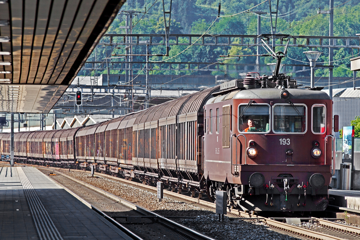 Viel heisse Luft strömt aus den Lüftergittern der Re 425 193  Steg  als sie mit einem Schiebewandwagen Ganzzug durch den Bahnhof Frenkendorf fährt.Bild Juli 2015