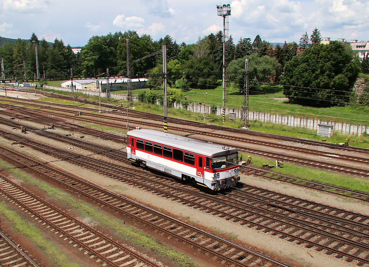 Viele Gleise und ein kleiner Dieseltriebwagen im Bahnhof Zvolen Osobna Stanica, aufgenommen von einer Strassenüberführung. Zvolen, 14.6.2023