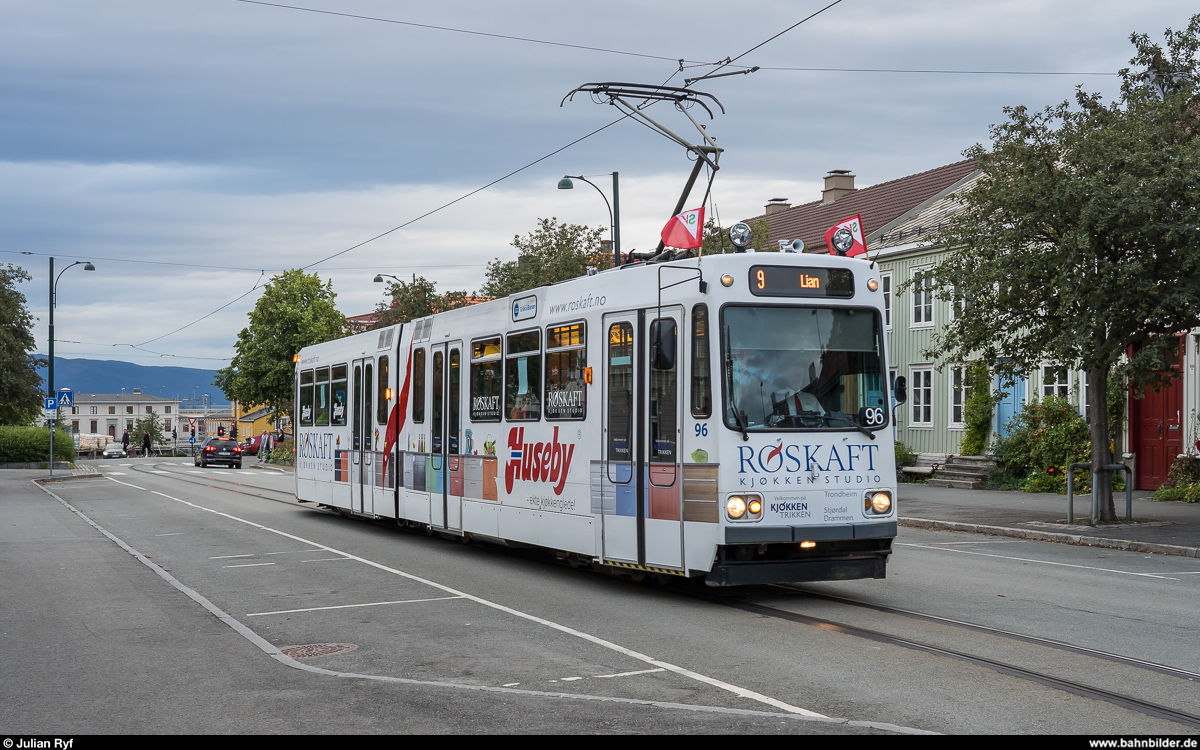 Viele Schmalspurbahnen gibt es in Norwegen nicht mehr und das obwohl ursprünglich die meisten Strecken in CAP-Spur errichtet wurden. In Trondheim jedoch gibt es eine meterspurige Tramlinie, die Gråkallbanen. Überbleibsel eines einst grösseren Netzes wird in den letzten Jahren wieder über einen Ausbau diskutiert.<br>
Am Abend des 30. August 2019 hat Wagen 96 gerade die stadtseitige Endstation St. Olavs gate verlassen und ist unterwegs nach Lian.