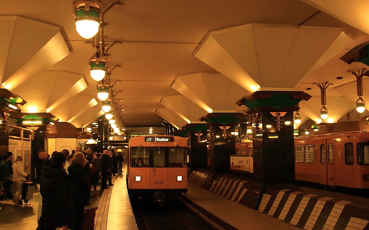 Völlig anders als der nüchtern-sachliche DB-Bahnhof Spandau präsentiert sich der in unmittelbarer Nachbarschaft gelegene U-Bahnhof Rathaus Spandau. Am 17.11.2015 fährt hier ein Zug der Linie U7 nach Rudow ein.