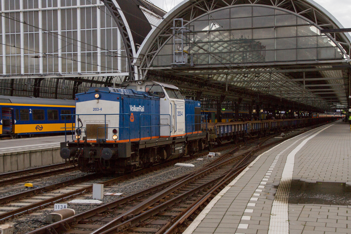Volker Rail 203-4 durchfährt Bahnhof Amsterdam Centraal mit einem Schotterzug, am 08.11.2022.