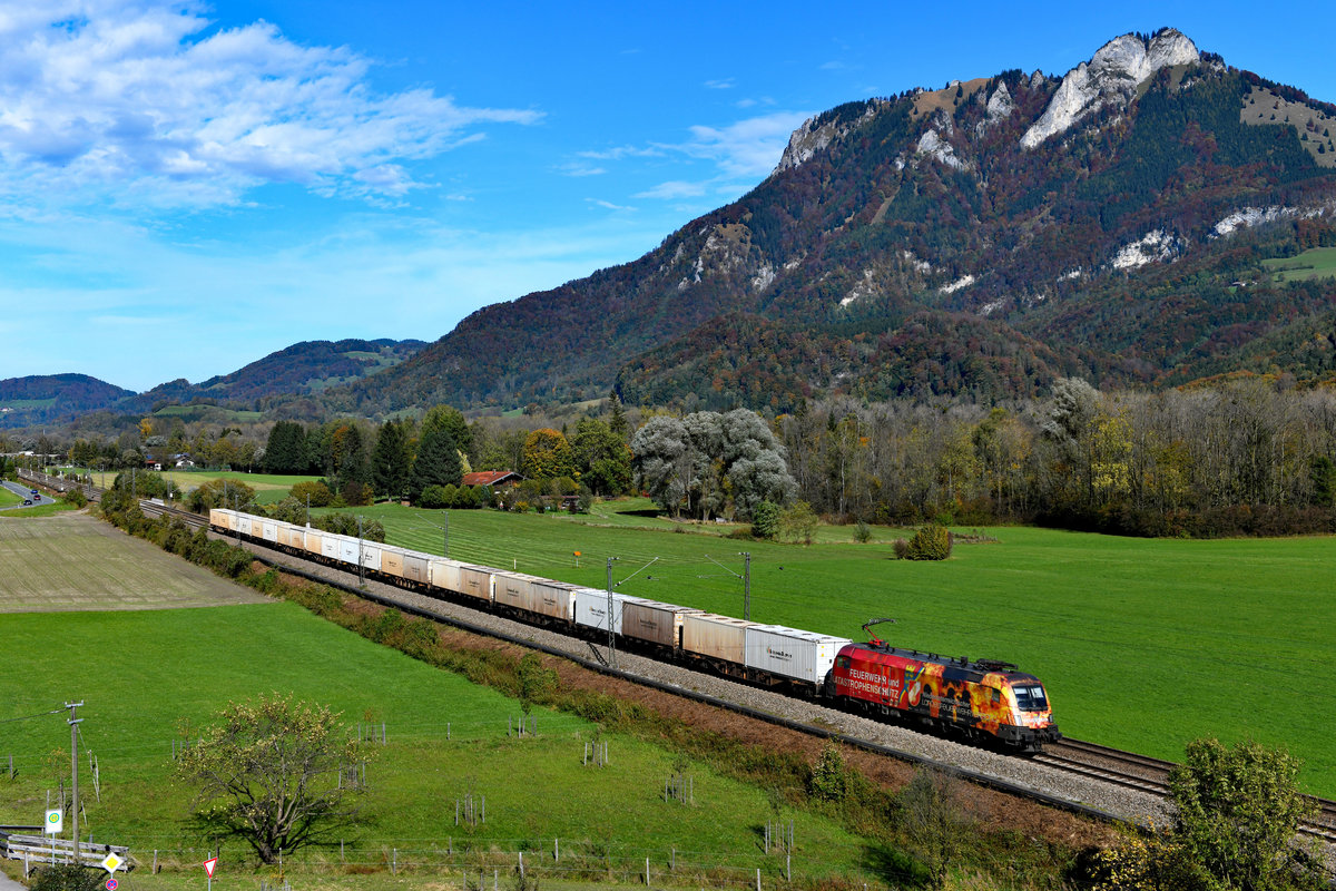 Vollkommen überrascht wurde ich am 18. Oktober 2019 direkt nach dem Aufstieg zu meinem Standpunkt bei Kirnstein im Inntal von der 1016.048, die an diesem Tage den KT 43885 von Plattling in Niederbayern nach Lonato in Italien führte. Der für den Niederösterreichischen Feuerwehrverband werbende Taurus wird den Container-Ganzzug bis zum Grenzbahnhof Brenner bringen. Ladegut in den weißen Containern ist übrigens raffinierter Zucker. 