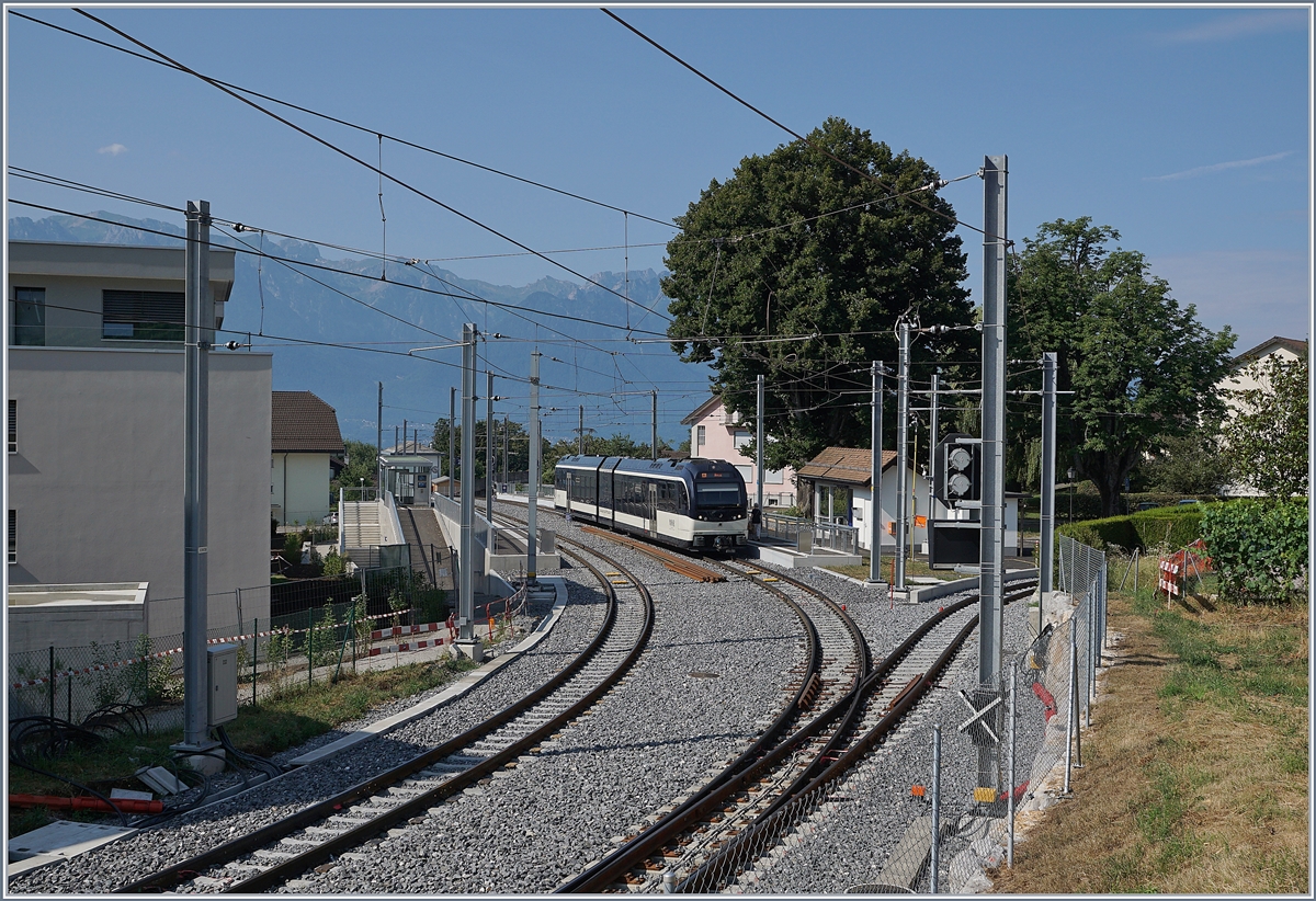 Vom dem etwa gleichen Blickwickel aus betrachte der nun umgebaute Bahnhof von St-Légier Gare mit dem von Vevey her eingetroffenen ABeh 2/6 7505, den schienenfreien Zugängen zu den beiden Gleisen und dem nun gestreckten Gleisbild.
Erhalten gebelieben bzw. aufwändig restauriert ist das Abstellgleis rechts im Bild, an welches sich früher als Fortsetzung die Strecke nach Châtel St-Denis anschloss. 

26. Juli 2019