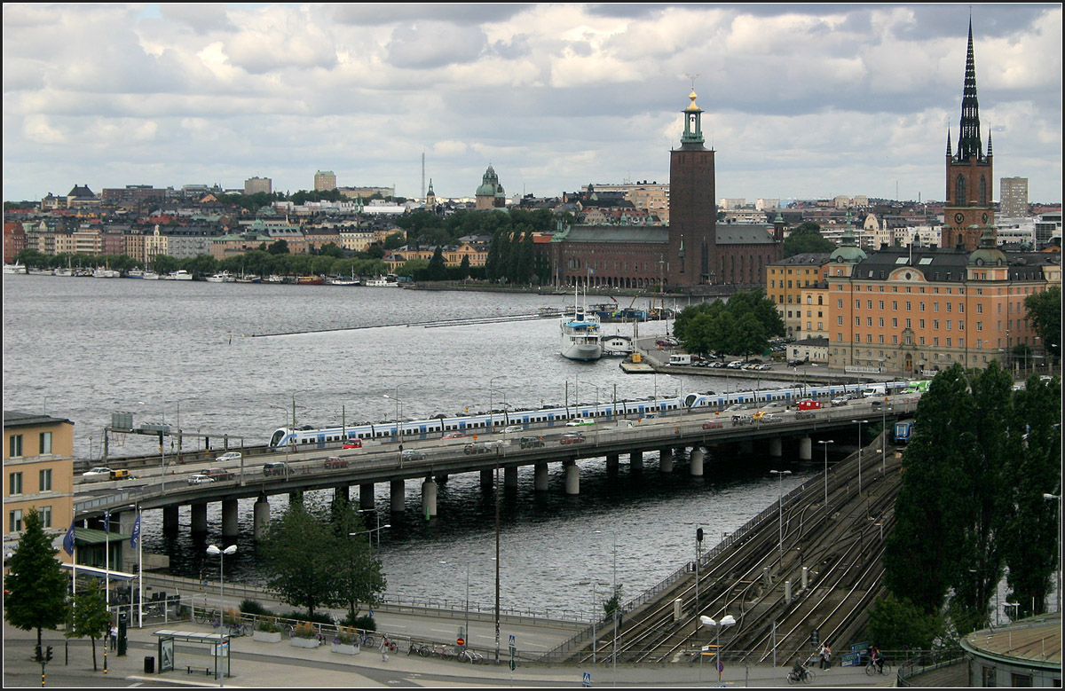 Vom Verkehr geprägt -

Im Bereich der Altstadt von Stockholm führen auch zahlreiche Verkehrsweg vom Nordteil in den Südteil der Stadt, die durch große Wasserflächen getrennt sind. Die Altstadt liegt als Insel dazwischen. Neben diversen breiten Straßen befinden sich hier auch die Gleise der Bahn, hier mit einem X60-Pendelzug und die viergleisige U-Bahn, rechts im Bild. Blick von Slussen nach Norden zum Stadthaus rechts der Bildmitte.

17.08.2007 (M)
