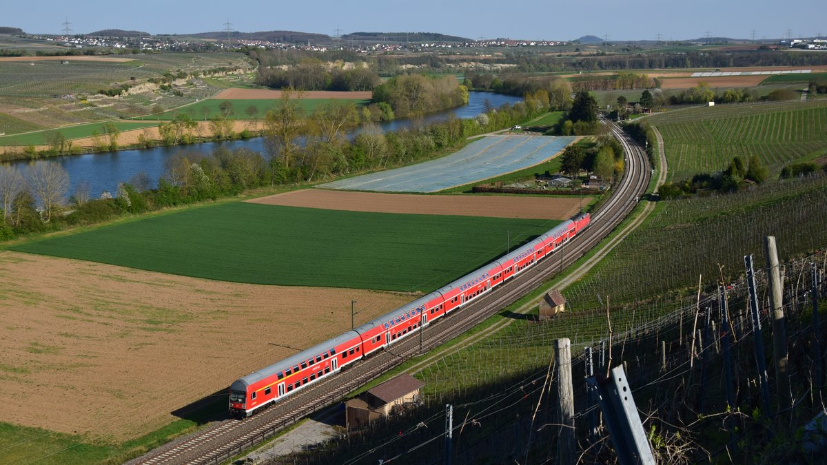 Von 2016 bis 2019 gab es auf der Frankenbahn zwischen Stuttgart und Osterburken Einsätze von DR-Dosto Garnituren. Eine solche ist hier am Abend des 18.04.2020 zwischen Lauffen (Neckar) und Nordheim (Württ.) unterhalb eines Weinhanges zu sehen. Im Hintergrund ist der Neckar zu sehen. Aufgenommen am 18.04.2020 19:16