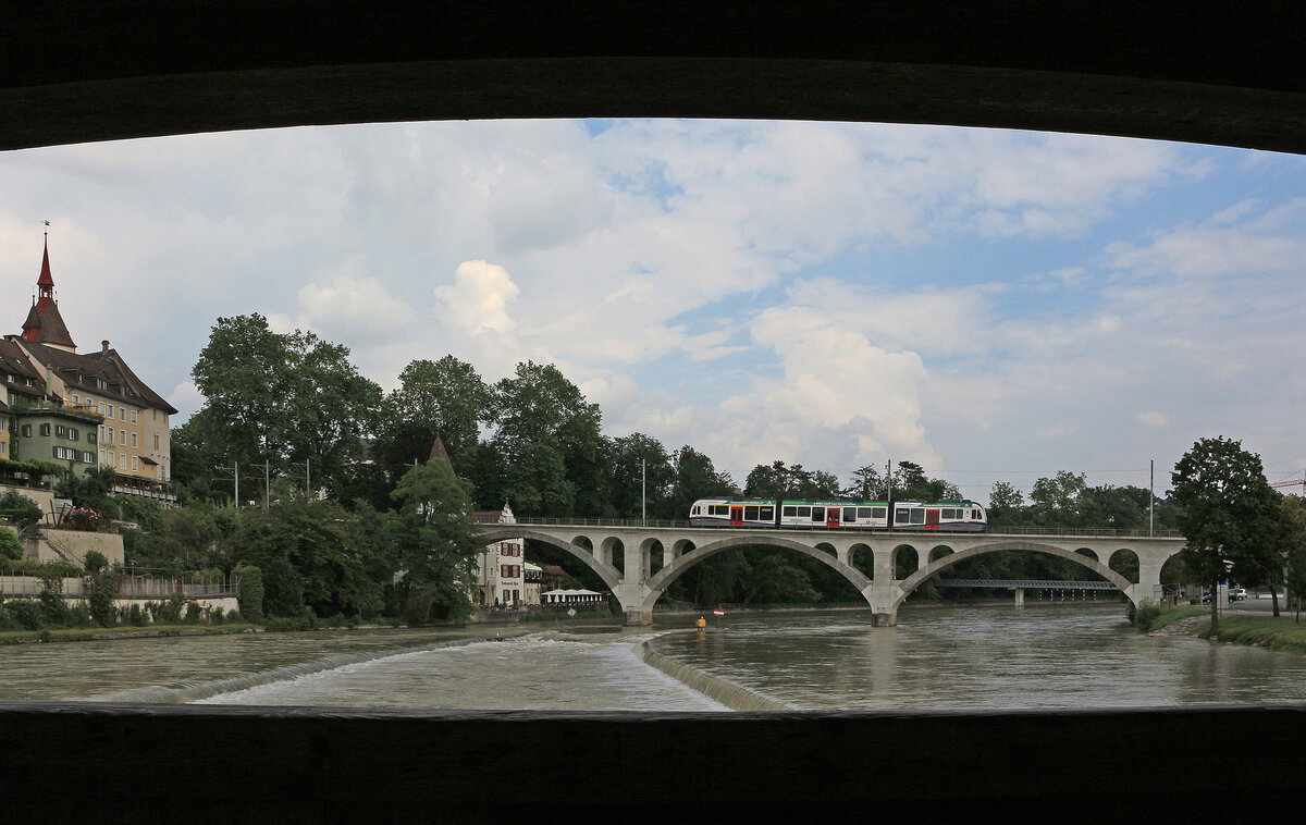 Von Brücke zu Brücke: Blick aus der gedeckten Holzbrücke in Bremgarten auf die Bahnbrücke mit einem ABe 4/8 am 25.07.2016.
