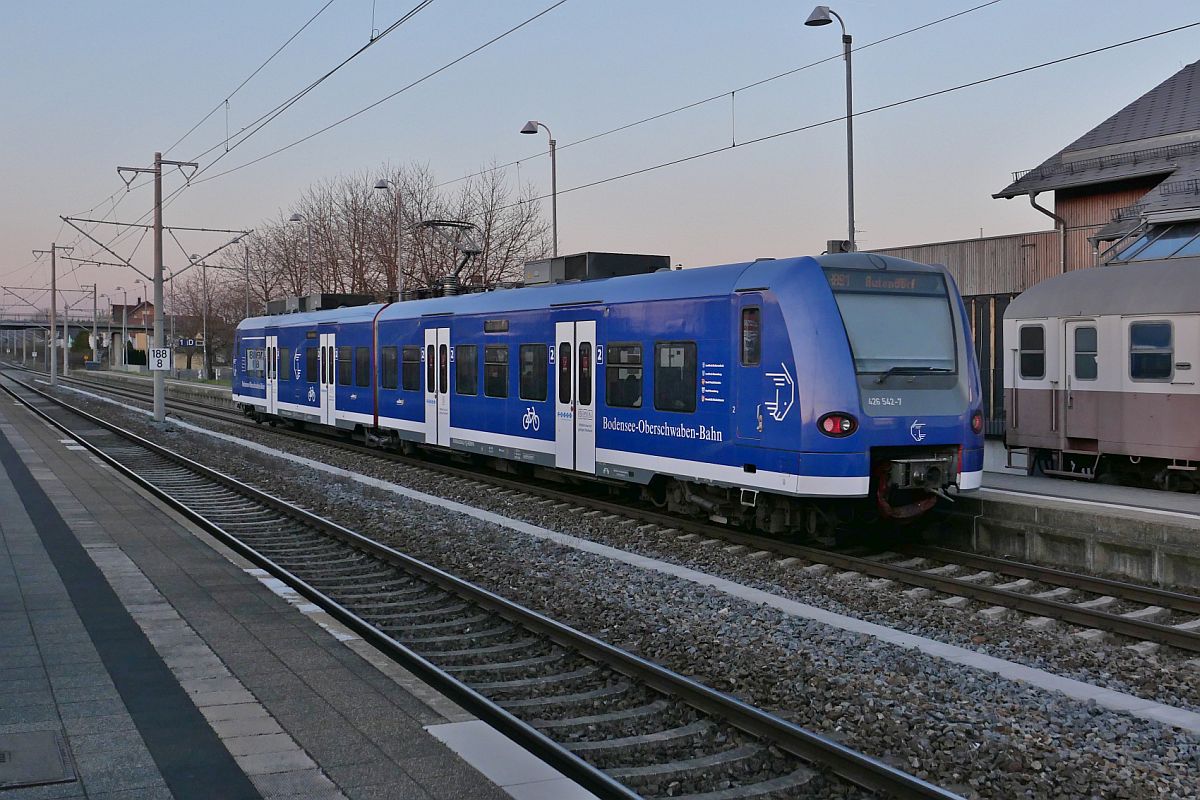 Von Friedrichshafen Hafen nach Aulendorf als RB 93 / 87590 fährt 426 542-7 / 426 042-8 der Bodensee-Oberschwaben-Bahn in Meckenbeuren ab (23.03.2022)