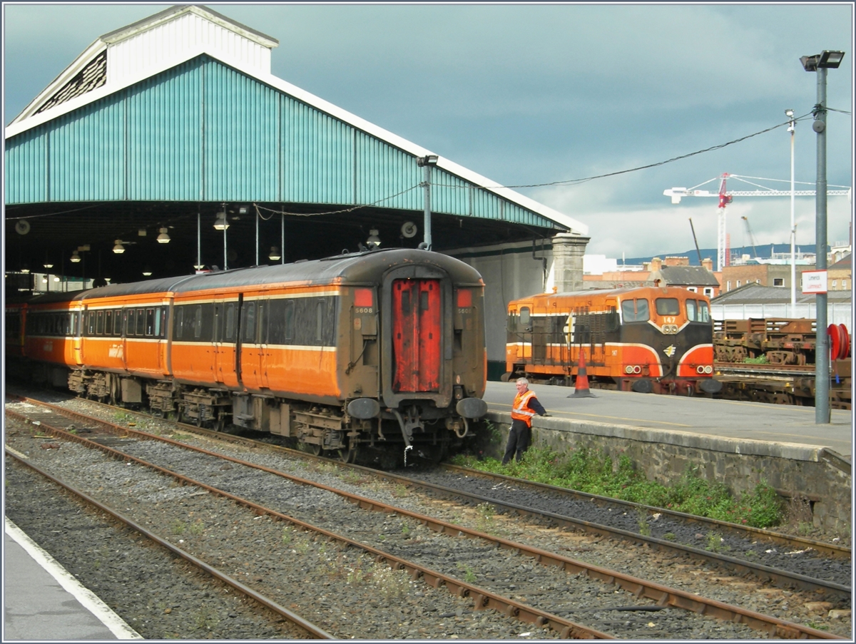 Von kommendenden, dunklen Regenwolken kaum beeindruckt wartet der Rangeierarbeiter gelassen, auf die Zuglok des 14h12 Zuges nach Dublin Heuston; auf dem Nebengleis steht die BB 147, welche die Komposition an den Bahnsteig manövrierte, doch neue Pendelzüge werden in Bälde solche Szenen auch in Irland Vergangenheit angehören lassen...
Limerick, den 4. Okt 2006