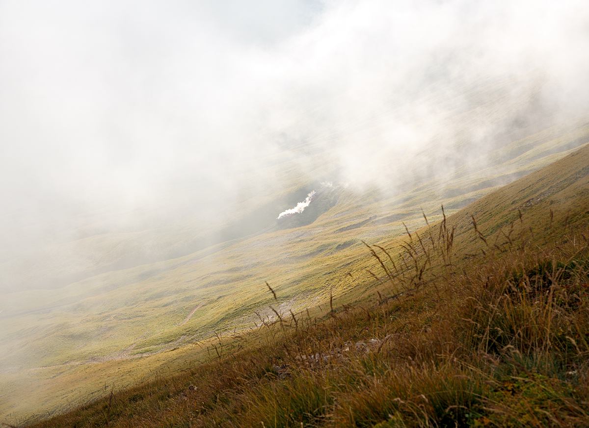 
Von Minute zu Minute kann sich das Wetter, Licht und Stimmung hier oben in den Bergen verändern, sehr schnell ist Nebel aufgezogen....
Doch sie ölgefeuerte Dampflok der BRB fährt im Nebel, mit dem letzten Zug dieses Tages, sicher talwärts vom Brienzer Rothorn noch Brienz hinab (24.09.2015, 17:49 Uhr). 