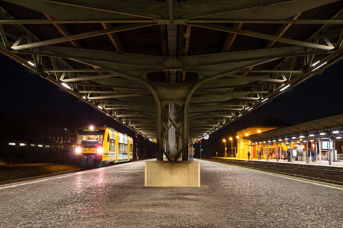 Von Montag bis Samstag leistet die ODEG mit einem Triebwagen der BR 650 alle zwei Stunden von Görlitz nach Bischofswerda u.z. Takt-Verstärkung im Fahrplan. Die hauptsächlichen Zugleistungen auf den KBS 230 (Dresden - Bischofswerda - Görlitz) und 235 (Dresden - Bischofswerda - Zittau (- Liberec)) u.z. werden von  Trilex , einer Tochtergesellschaft der Vogtlandbahn, erbracht.

Am Abend des 23.12.2015 hat ODEG 650.084 gerade Fahrgäste u.a. von der Grenzstadt an der Neiße nach Bischofswerda gebracht. Diejenigen, die in die Doppeleinheit der BR 642 von  Trilex , welche von Liberec (Tschechien) nach Dresden verkehrt, umsteigen wollen, haben sich soeben am Bahnsteig 1 eingefunden und warten nur wenige Minuten auf ihren Anschlußzug.

Nachdem auch ein paar Fahrgäste, von dessen Gegenzug von Dresden nach Zittau in Richtung Görlitz umstiegen, trat der ODEG 650.084 seine Rückfahrt an.

Zum Zeitpunkt der Aufnahme wechselte der Lokführer des 650 gerade die Farbe seiner Spitzenlichter von Schlußlicht nach Frontlicht.
Der Bahnhof Bischofswerda besitzt glücklicherweise noch große Teile der Bahnsteigüberdachung, welche am Insel-Bahnsteig zu den Gleisen 2 und 3 noch vollends erhalten ist. 