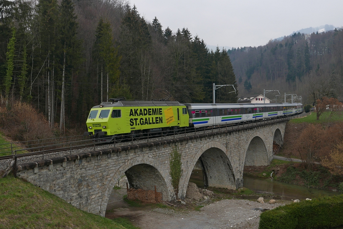 Von Romanshorn kommend zieht Re 446 018-4 am 28.02.2016 den VAE 2580 nach Luzern. Kurz nach dem 8.603 m langen Rickentunnel überquert der Voralpen-Express den Viadukt in Kaltbrunn.