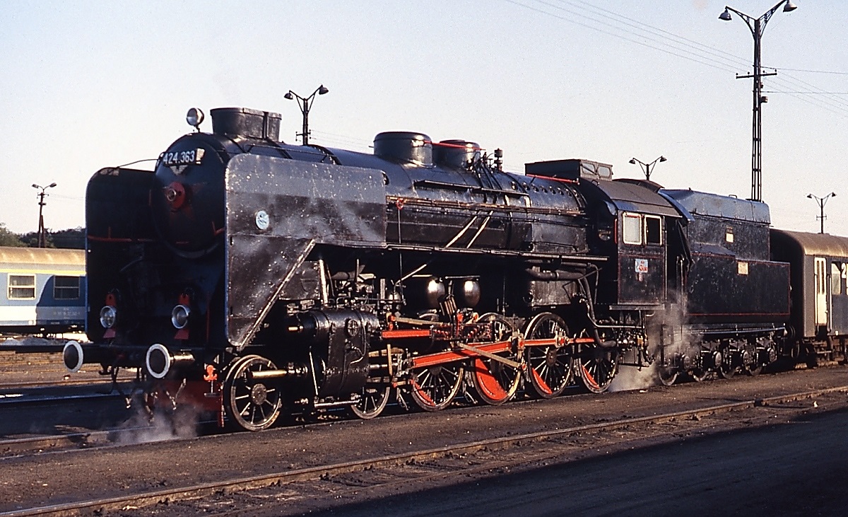 Von der schon tiefstehenden Nachmittagssonne optimal ausgeleuchtet steht die 424.363 im Oktober 1978 vor einem Personenzug nach Sopron im Bahnhof Szombathely. Zu diesem Zeitpunkt waren die 424 noch im ganzen Land anzutreffen.