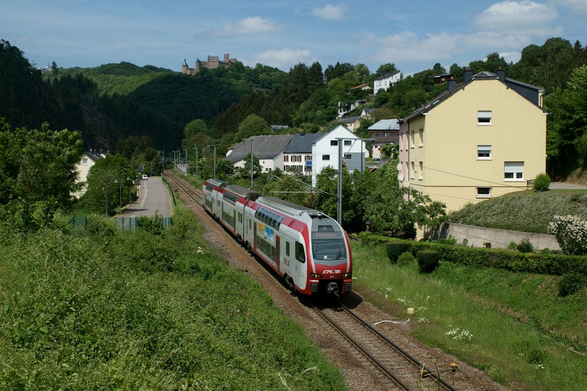 Von Troisvierges kommend war CFL Kiss 2301 als RE 3787 auf dem Weg nach Luxembourg Ville. Vor der Kulisse von Burg Bourscheid erreicht der Zug in Kürze den Haltepunkt Michelau.