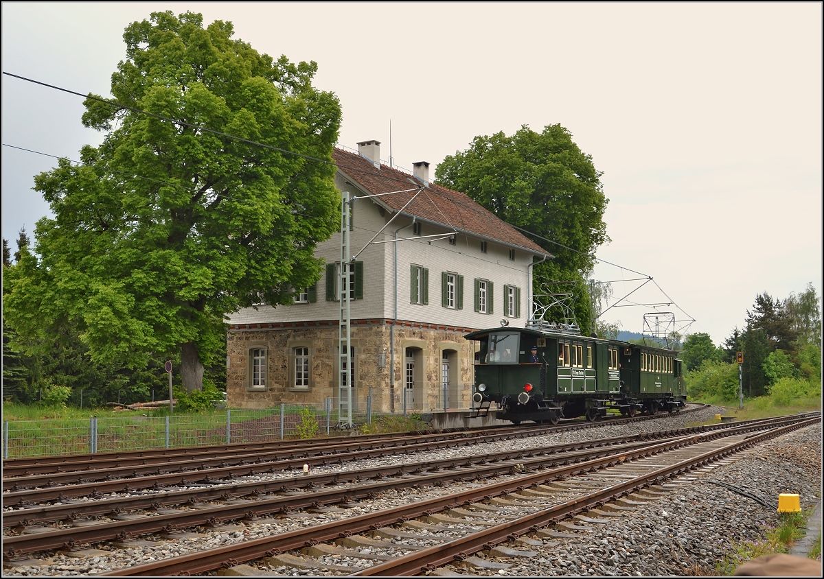 Von zwei mächtigen Bäumen ist das ehemalige Empfangsgebäude des Trossinger Staatsbahnhofs gesäumt. Davor der Originalzug vom Betriebsstart der Trossinger Eisenbahn mit dem Triebwagen Zeug Christe am Zugschluss. Mai 2015.