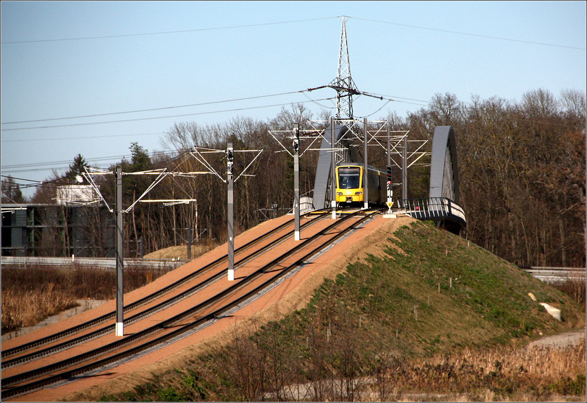 Vor der Abfahrt ins 'Tal' - 

... oder: Absteigende Masten. 

Ein Triebwagen der Stuttgarter Stadtbahnlinie U6 auf der Brücke über der Autobahn A8 beim Fasanenhof.

27.02.2022 (M)