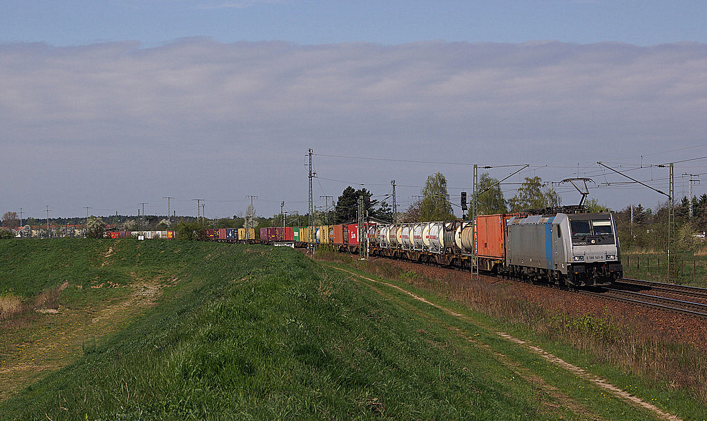 Vor einer aufziehenden Wolkenfront entschwindet 186 141, damals im Einsatz für Metrans, durch Zeithain in Richtung Elbtal. 11.04.2014