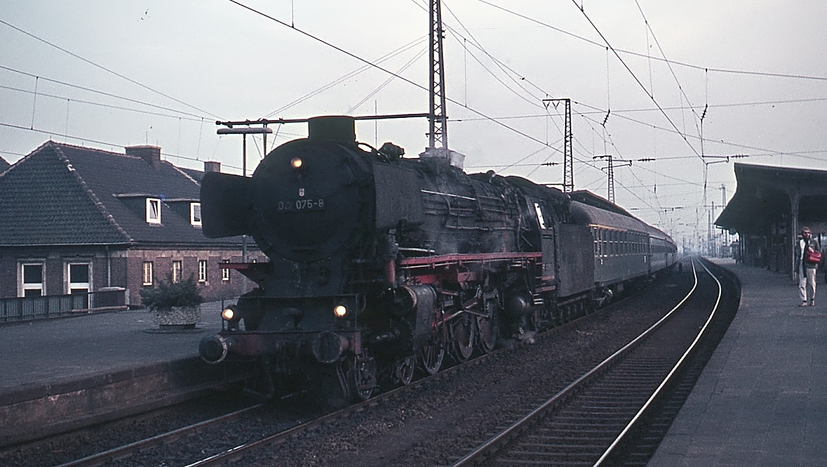 Vor dem abendlichen Schnellzug in Richtung Emden wartet 012 075-8 im Spätwinter 1975 im Bahnhof Rheine auf die Ausfahrt. Die Lok wurde 1991 auf Rostfeuerung zurückgebaut und gehört heute der Stoom Stichting Nederland.