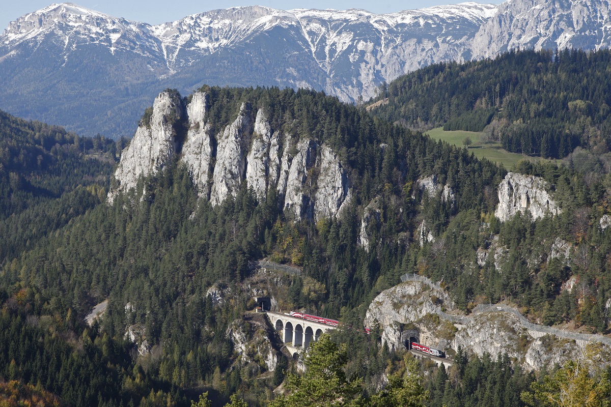 Vor dem Bergmassiv der Rax um Fuße der Polleroswand fährt 1116.249 (Lange Fahne) über den Krauselkauseviadukt der Semmeringbahn. Das Bild wurde am 27.10.2014 vom sogenannten Zwanzigschillingblick von der gegenüberliegenden Talseite aufgenommen.