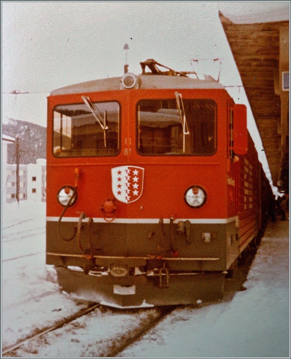Vor dem Einsatz als  Tunnellok  für die Autozüge durch den Furkatunnel hatte die FO keinen Bedarf an den bereits erhaltenen zwei Ge 4/4 III 81 und 82 und so wurden sie bei der RhB eingesetzt. 
Im Bild die FO Ge 4/4 III 81  Wallis  abfahrbereit mit einem Reisezug nach Landquart in Davos Platz. 

Analog Bild vom Winter 1981/82
