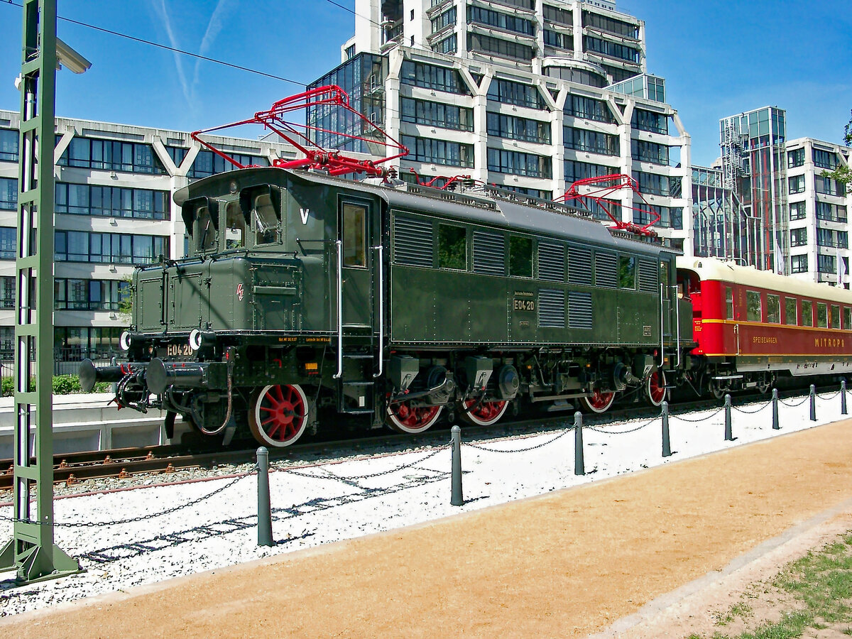 Vor dem Gebäude der DB-Zentrale in Frankfurt am Main steht am 04.05.2003 die aufgearbeitete E 04 20 mit einem Mitropa-Speisewagen als Denkmallokomotive. Zuvor war die Lok im Aw. München-Neuaubing abgestellt - siehe meine Aufnahmevom 28.10.1983.