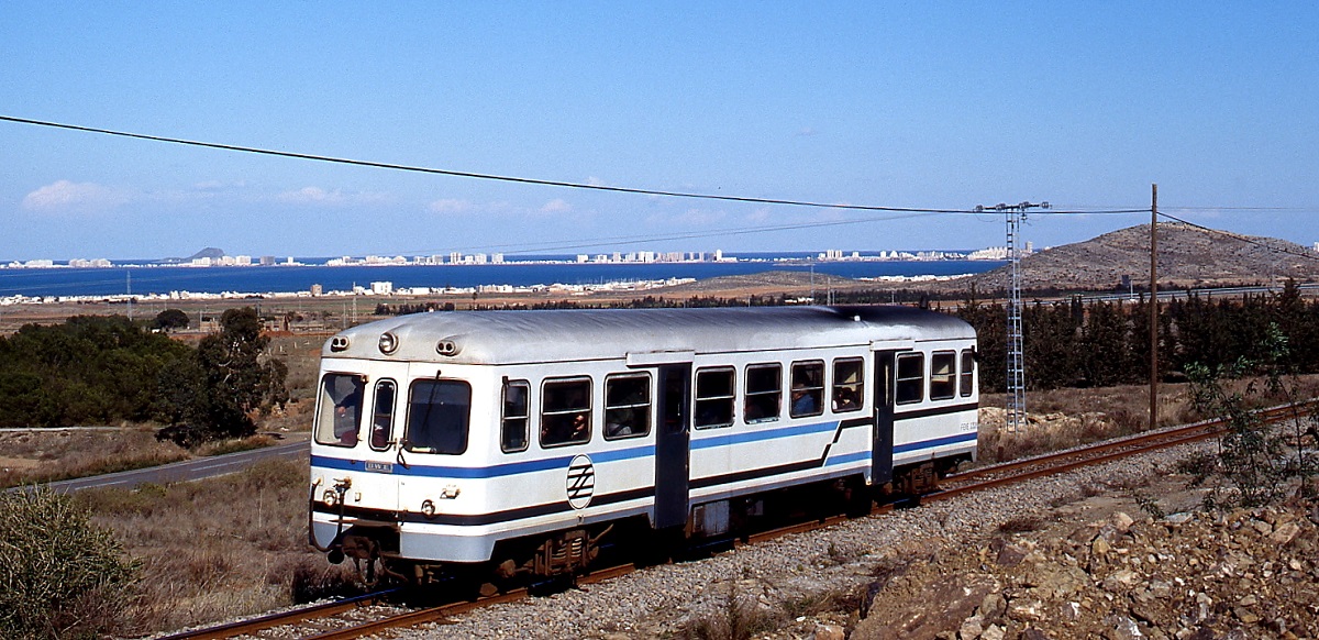 Vor dem Panorama von Los Nietos fährt ein Triebwagen der FEVE-Reihe 2300 im Februar 1996 nach Cartagena