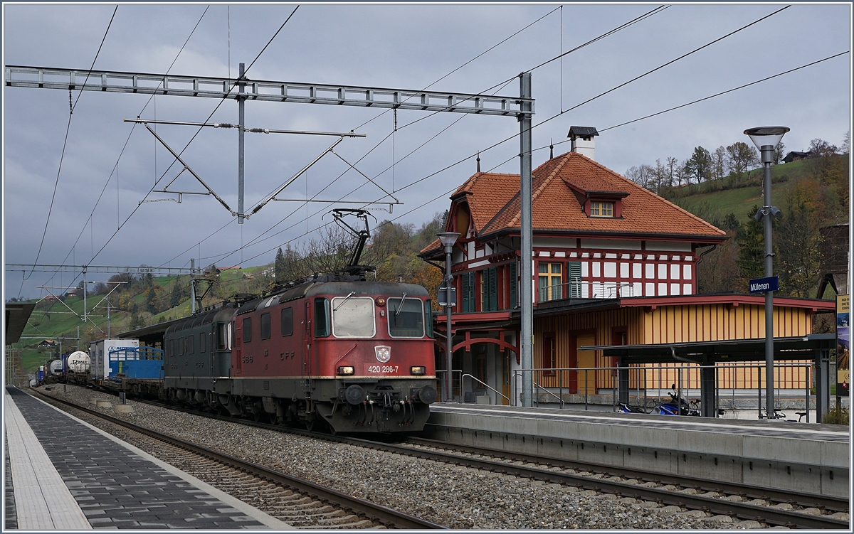 Vor dem schmucken Bahnhofsgebäude von Mülenen zeigten sich die Re 420 286-7 und die letzte  grüne Re 6/6 11663 mit einem Güterzug Richtung Süden. 
30. Okt. 2017