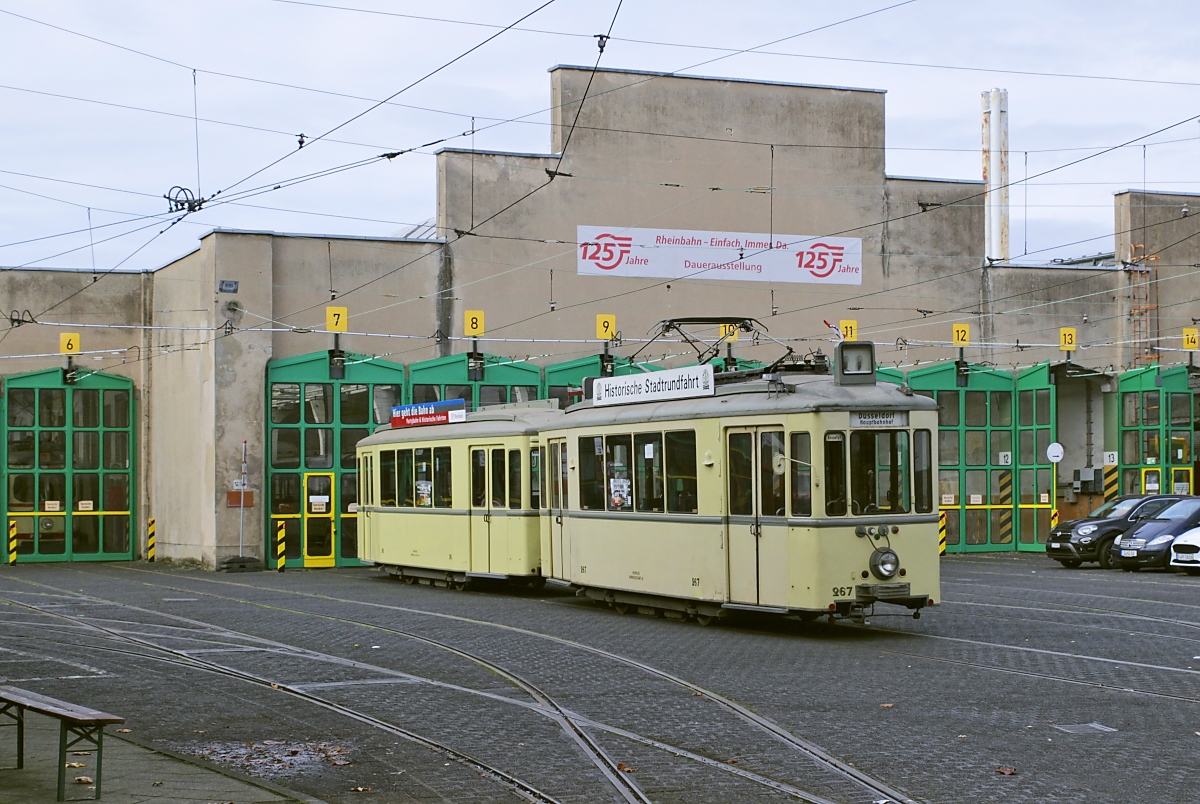 Vor den denkmalgeschützten Hallen des 1908 eröffneten Rheinbahn-Betriebshofes Am Steinberg ist der 1937 gebaute Niederflurtriebwagen 267 mit dem Beiwagen 316 am 06.11.2021 abgestellt