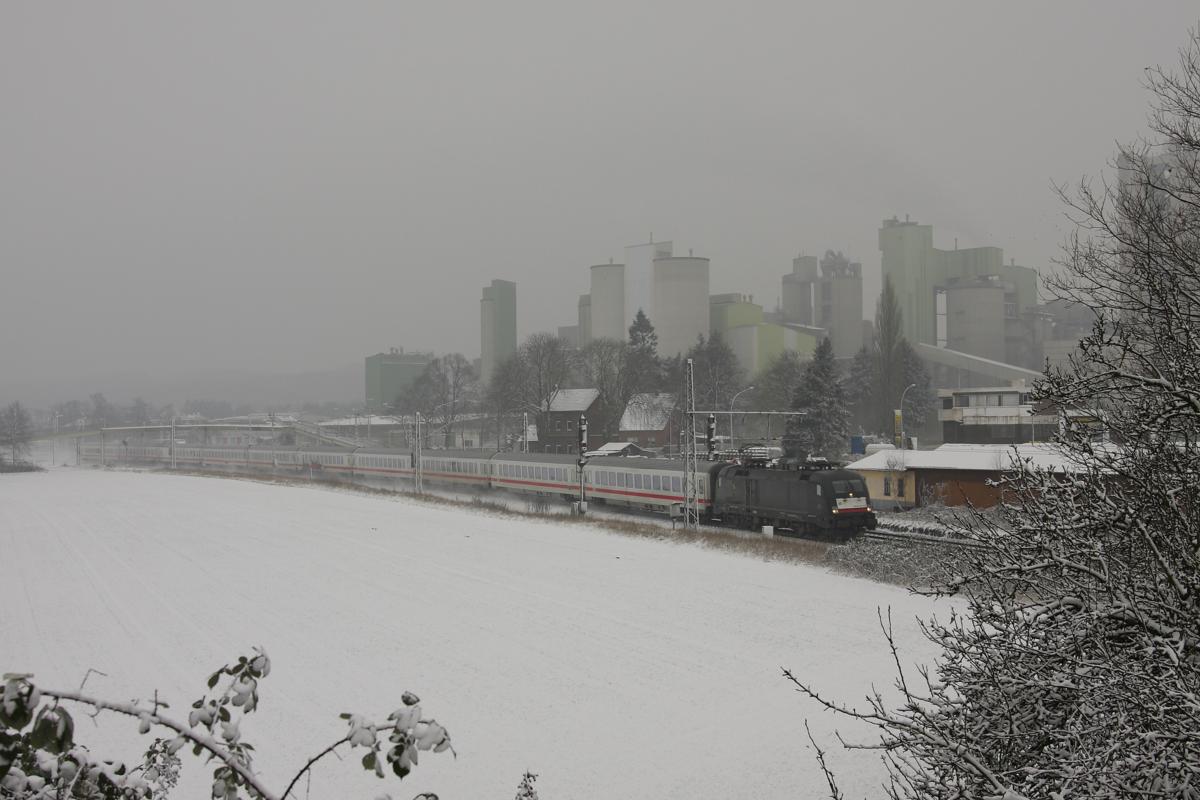 Vor der im Dunst fast verschwindenden Kulisse der Buzzi Werke, ehemals Dyckerhoff,
in Lengerich fährt ein Taurus am 26.01.2014 mit dem IC 2023 um 10.06 Uhr stark verspätet nach Frankfurt.