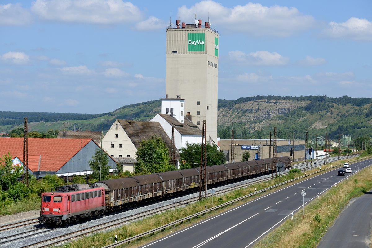 Vor gar nicht allzu langer Zeit waren die Einheitsloks zum Teil noch präsenter als es die 185-er heutzutage sind. Inzwischen haben sich die 140-er schon sehr rar auf deutschen Schienen gemacht und sind zum Großteil den Weg des alten Eisens gegangen. Ein paar Exemplare haben ihr Ausgedinge bei privaten EVU gefunden, so z.B. die 140 856, die für die BayernBahn fährt. Haupteinsatzzweck ist die Beförderung des sogenannten Henkelzuges, der von Langenfeld nach Wassertrüdingen und zurück verkehrt. Zugnummer ist DGS 75807, aufgenommen wurde die Leistung am 20. Juli 2013 bei Karlstadt. Nettes Detail am Rande: Vergrößert man das Bild, erkennt man, wie der Tf gerade im Führerstand die Pfeife bedient, um die Fotografen zu grüßen.