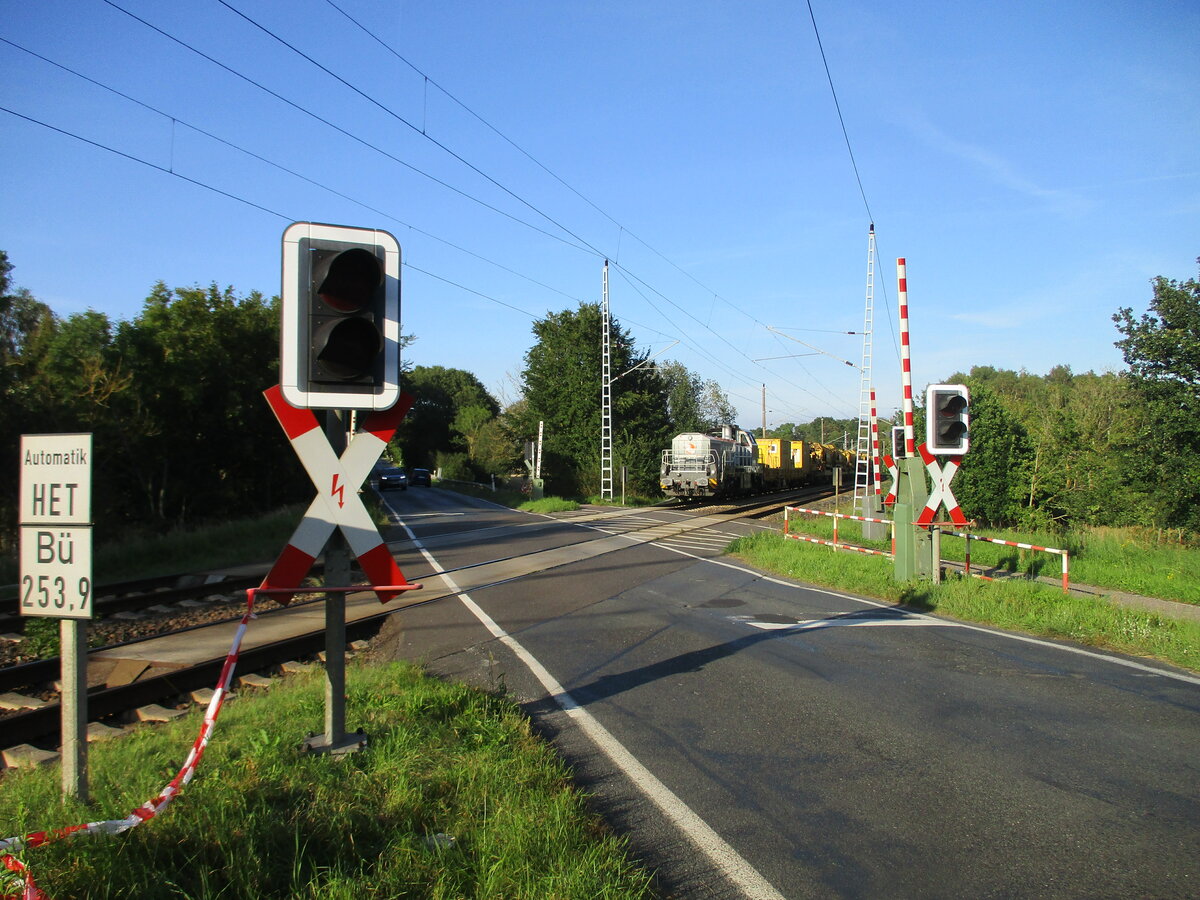 Vor der geöffneten Schranke,bei Bergen/Rügen,stand die NXRL 185 026,am 07.September 2023,mit ihrem Bauzug.