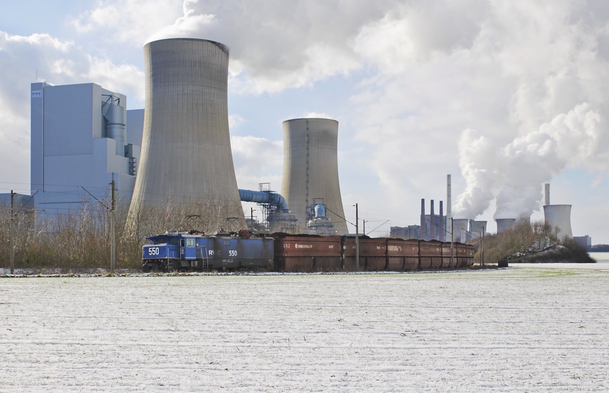 Vor den gewaltigen Anlagen des Kraftwerkes Neurath wartet RWE Power 550 mit dem Braunkohlezug vom vorherigen Bild am 12.02.2021 auf die Weiterfahrt zur Entladung. Mit einer Leistung von über 4.411 Megawatt ist Neurath das größte Kraftwerk Deutschlands und das zweitgrößte Braunkohlekraftwerk Europas, 2015 lag es mit CO2-Treibhausgasemissionen von 32,1 Mio. Tonnen auf PLatz 2 aller europäischen Kraftwerke (Quelle: wikipedia).